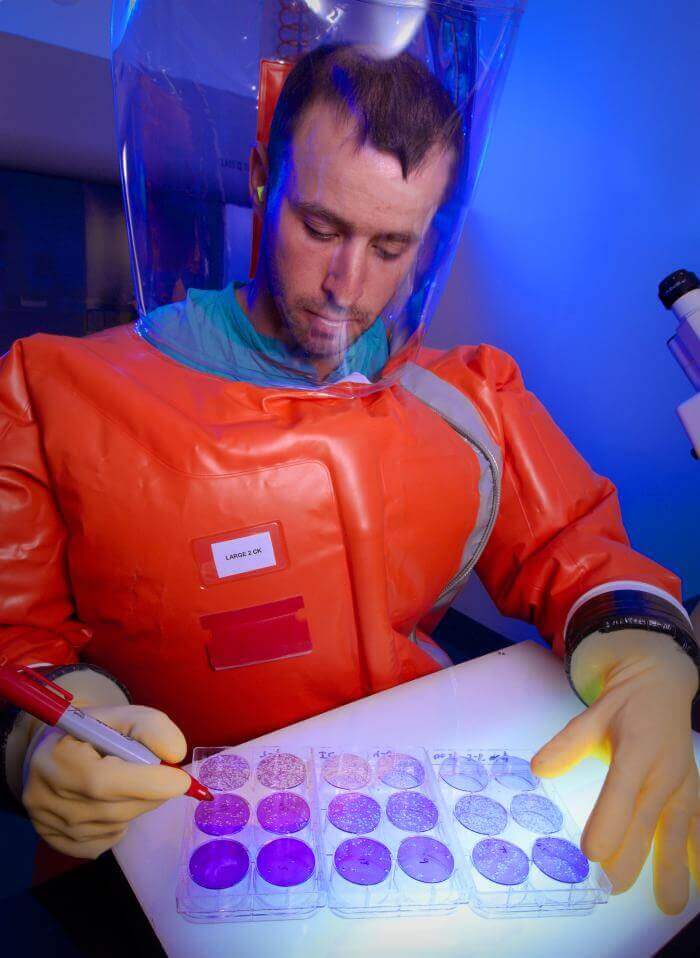 CDC researcher handles pathogen in biosafety lab. Photo: CDC/ Dr. Scott Smith