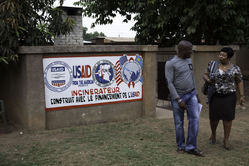 Man and woman standing in front of a sign that reads "USAID." (PATH/Felix Masi)